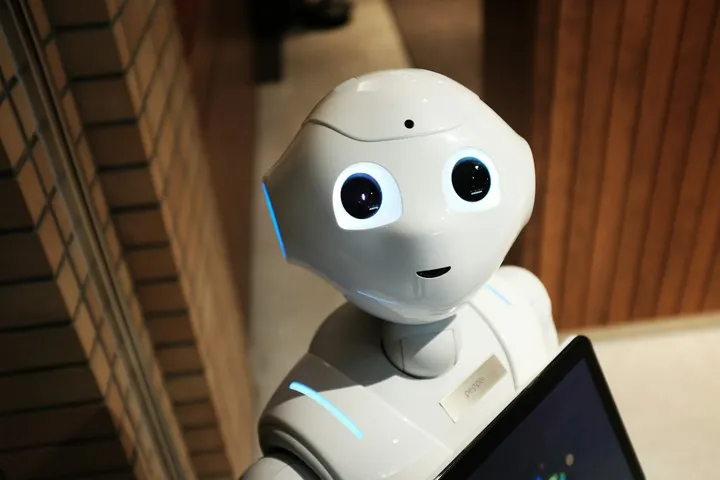 Robot humanoide blanco mirando de frente en una oficina