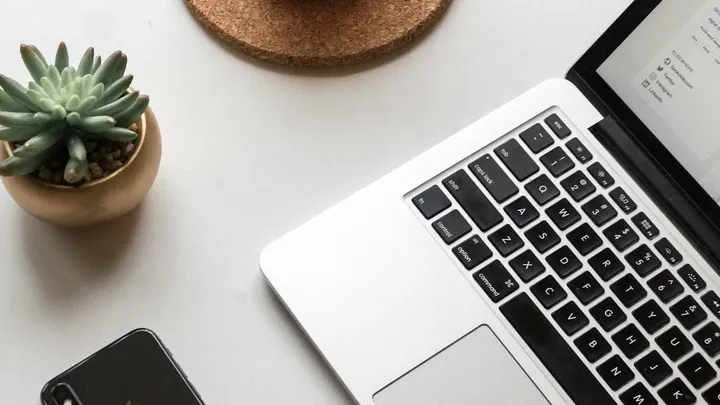 Teléfono móvil y laptop sobre un escritorio de trabajo