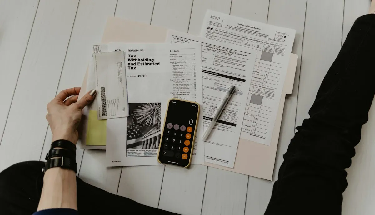 Facturas y documentos sobre un escritorio junto a una calculadora en un teléfono