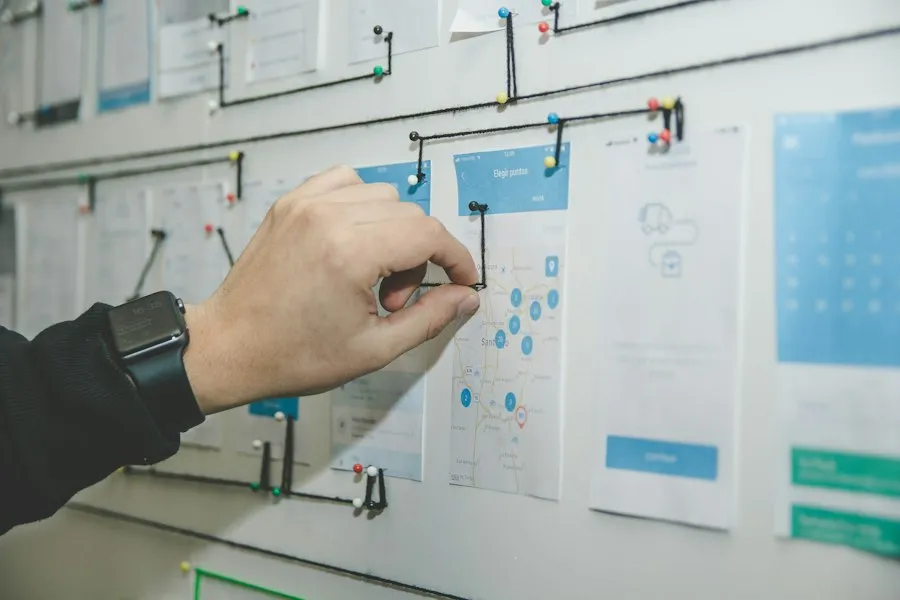 Hand pinning app wireframes on a planning wall