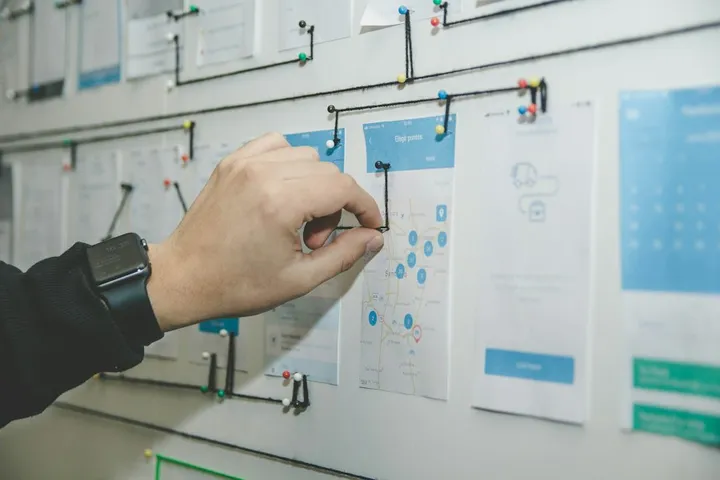 Hand pinning app wireframes on a planning wall