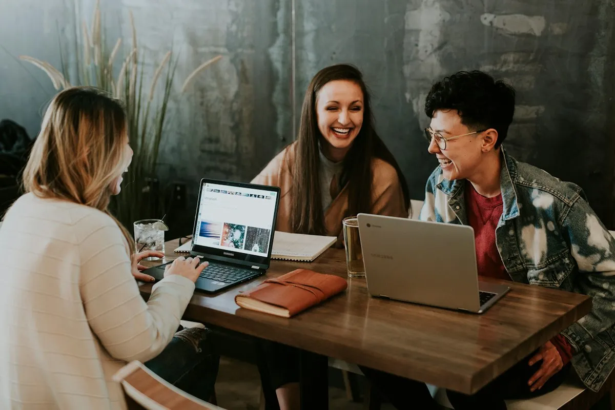 Equipo de trabajo conversando frente a laptops en una mesa