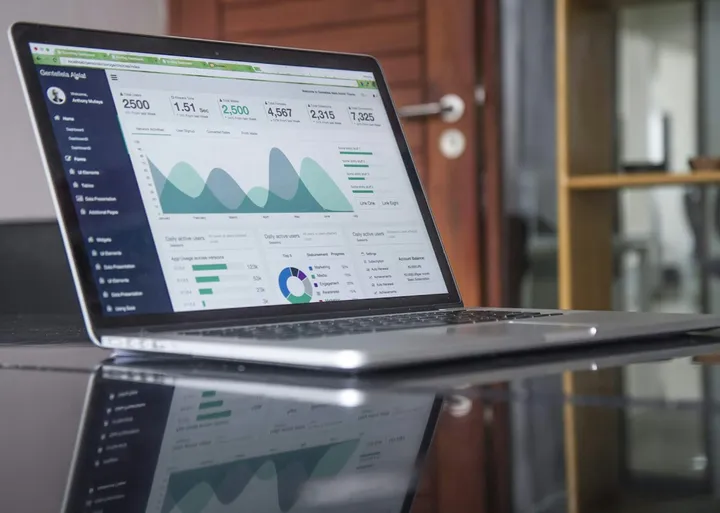 Laptop mostrando un panel de indicadores y gráficas sobre un escritorio