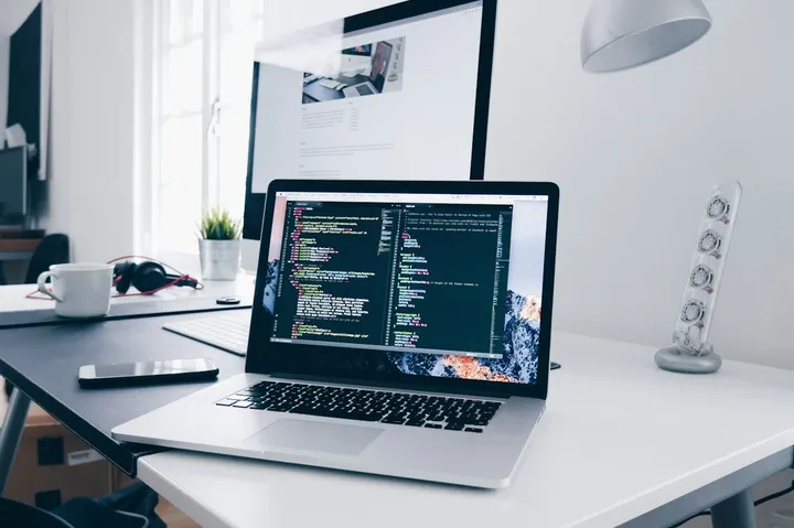 Laptop con un editor de código abierto en un escritorio de trabajo