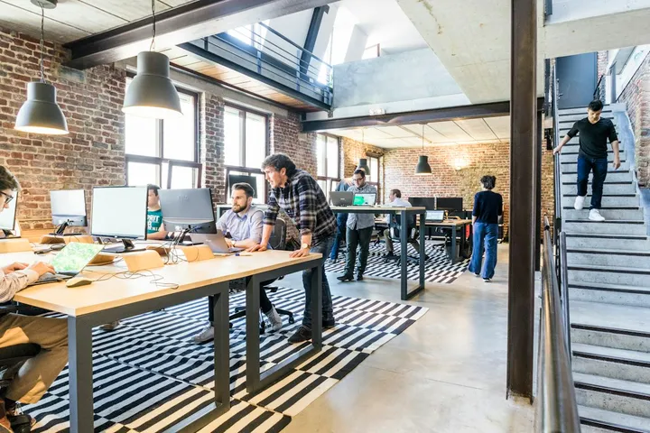 Oficina de una startup con personas trabajando en varios escritorios
